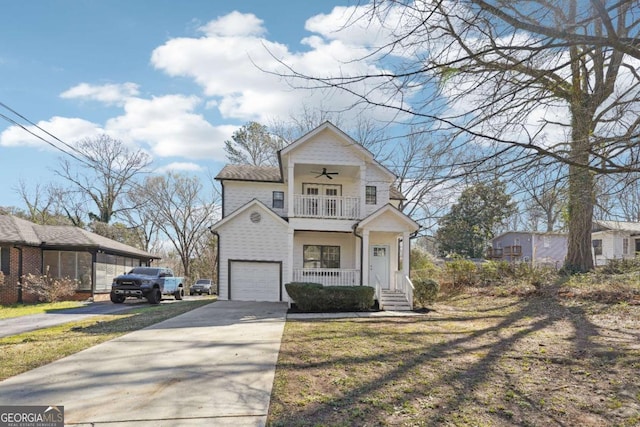 view of front of property featuring concrete driveway, covered porch, a garage, a balcony, and a ceiling fan