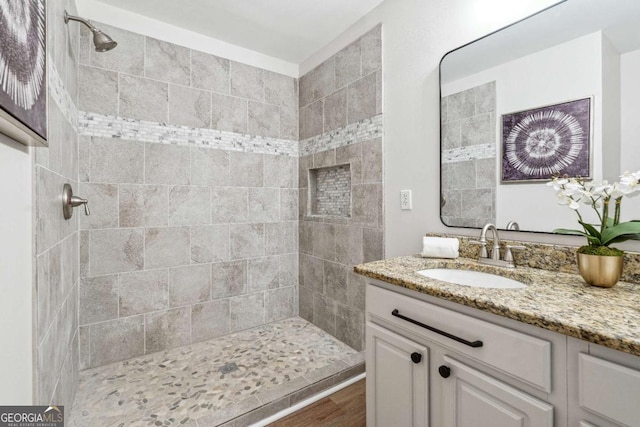 full bath with vanity and tiled shower