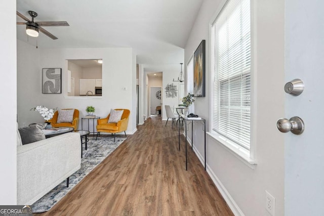 living area featuring a healthy amount of sunlight, baseboards, and wood finished floors