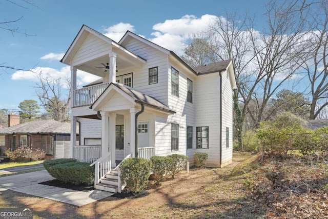 view of front of house featuring a balcony and a ceiling fan