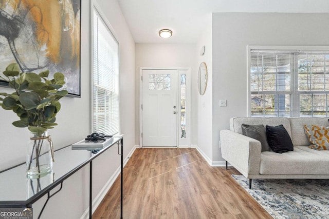 foyer entrance with baseboards and light wood-style flooring