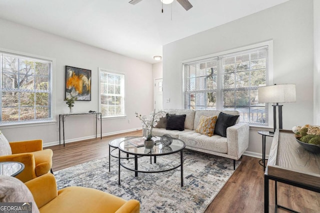 living room featuring wood finished floors, baseboards, and ceiling fan