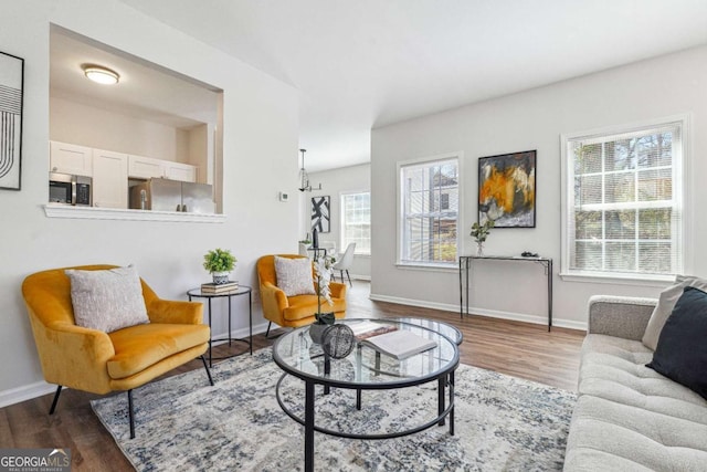 living area with baseboards and wood finished floors