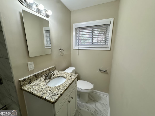 bathroom with marble finish floor, toilet, vanity, and baseboards