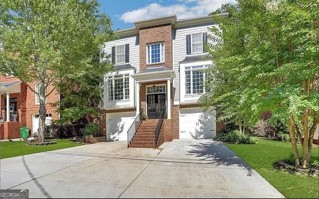 view of front of house with brick siding, an attached garage, concrete driveway, and a front lawn