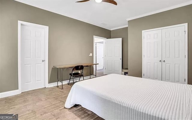 bedroom with crown molding, baseboards, wood finished floors, a closet, and a ceiling fan