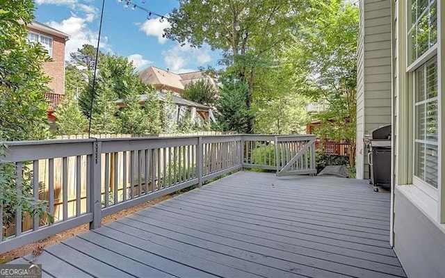 wooden deck featuring a grill