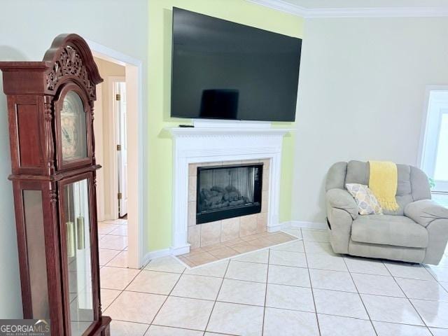 living area featuring light tile patterned floors, baseboards, ornamental molding, and a tile fireplace