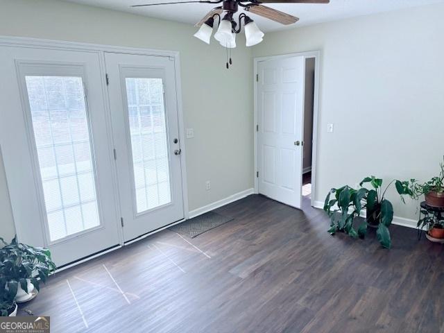 doorway with ceiling fan, baseboards, and wood finished floors