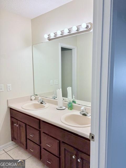 full bathroom featuring a sink, double vanity, and tile patterned flooring