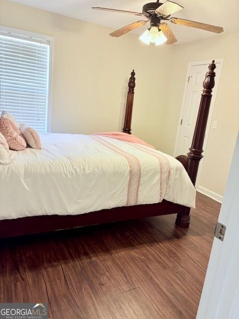 bedroom with wood finished floors, baseboards, and ceiling fan