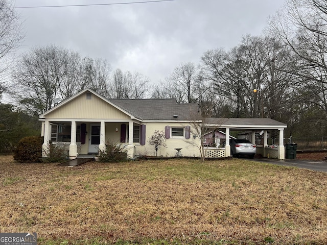 view of front facade featuring an attached carport, driveway, a porch, a shingled roof, and a front lawn