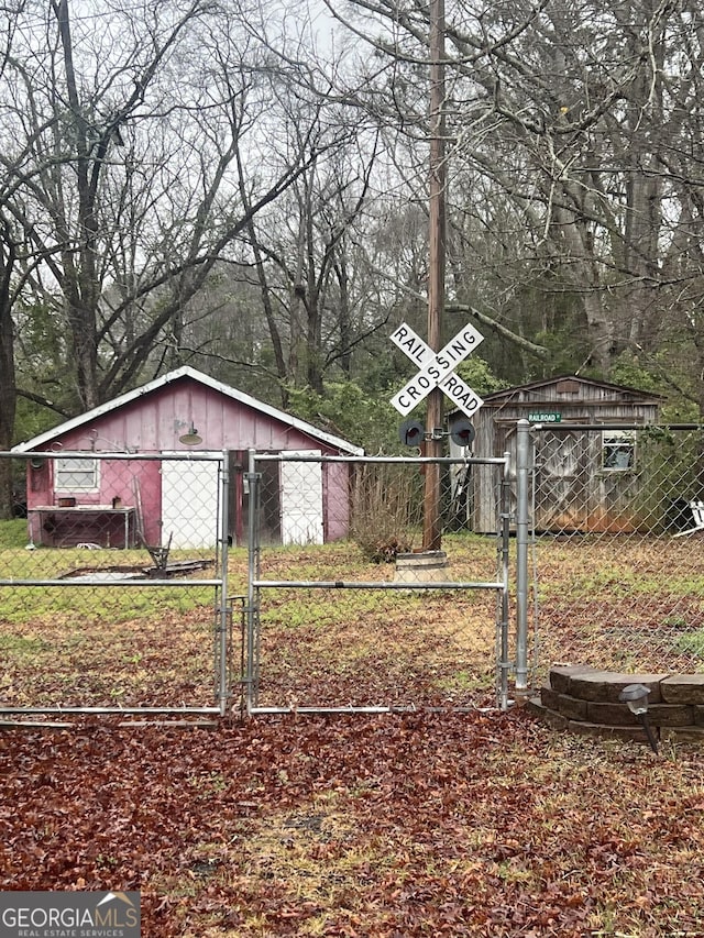 view of yard with fence, an outdoor structure, and a gate