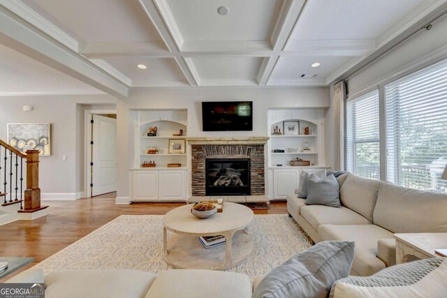 living room with beam ceiling, stairway, light wood-style flooring, and coffered ceiling