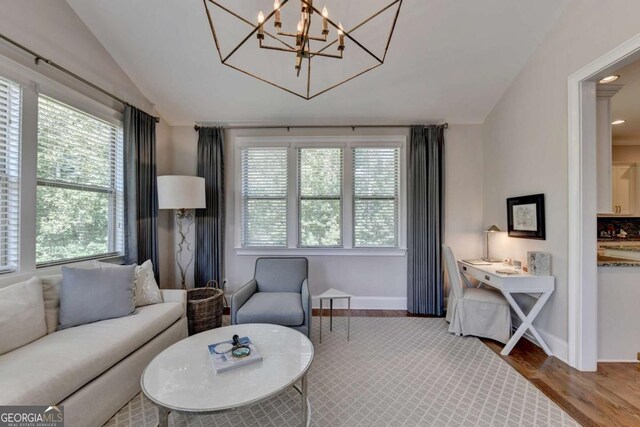 living room featuring wood finished floors, baseboards, and vaulted ceiling