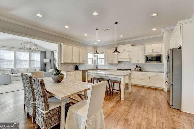 dining room with crown molding, visible vents, a chandelier, and light wood-type flooring