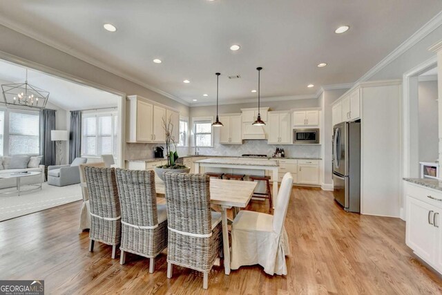 dining area featuring a notable chandelier, recessed lighting, crown molding, and light wood-style floors