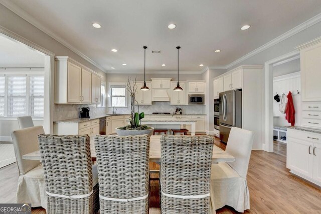 dining space featuring recessed lighting, light wood-style flooring, and crown molding