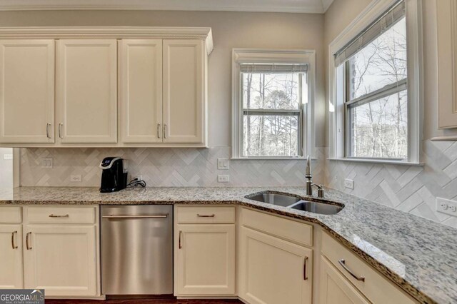 kitchen featuring decorative backsplash, light stone countertops, and a sink