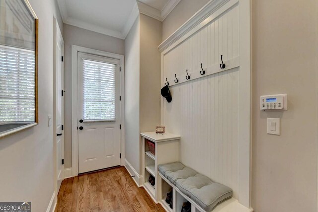 mudroom featuring light wood-style flooring, baseboards, and ornamental molding