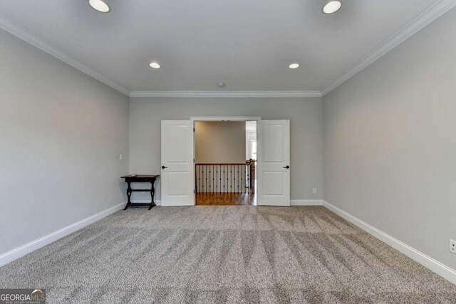 carpeted spare room with recessed lighting, baseboards, and ornamental molding