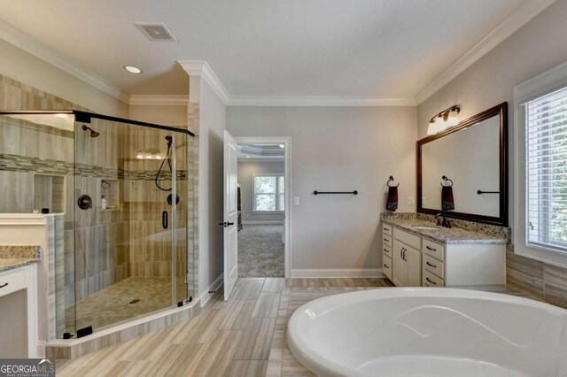 full bath with visible vents, a bathing tub, a healthy amount of sunlight, and vanity