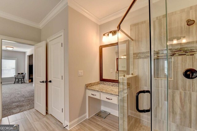 bathroom with baseboards, vanity, a stall shower, and crown molding