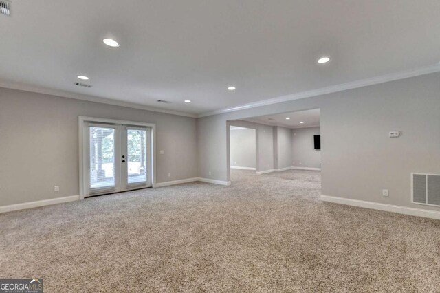 unfurnished room with ornamental molding, baseboards, visible vents, and light carpet