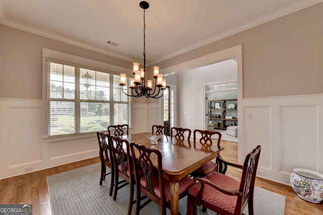 dining area featuring a decorative wall, visible vents, and a chandelier