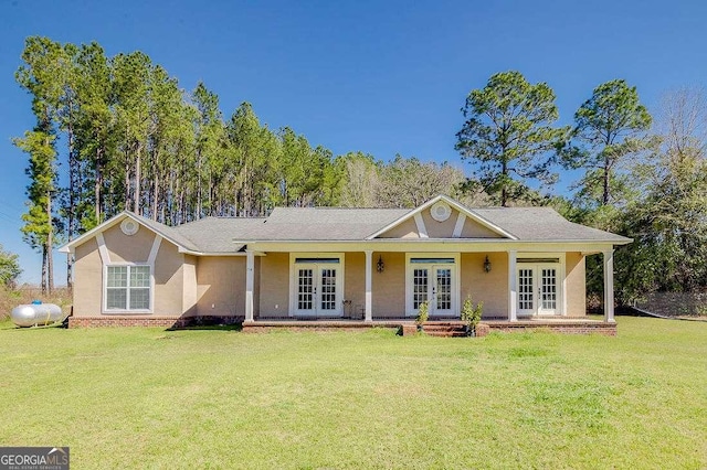 ranch-style house with a front lawn, french doors, and stucco siding