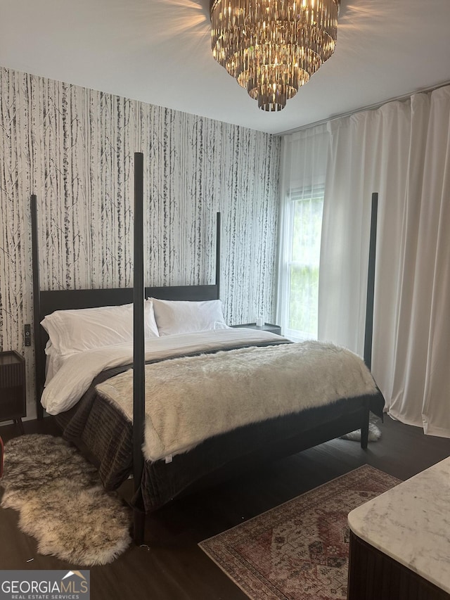 bedroom with wallpapered walls and a notable chandelier