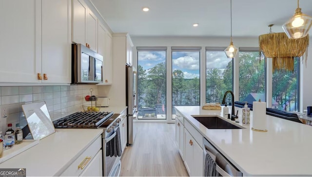 kitchen with appliances with stainless steel finishes, light countertops, and a sink