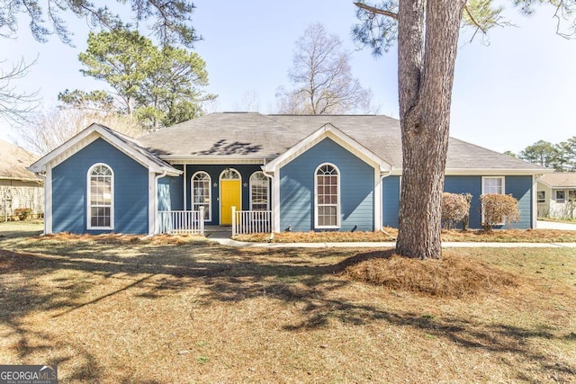 ranch-style home featuring a porch and a front lawn