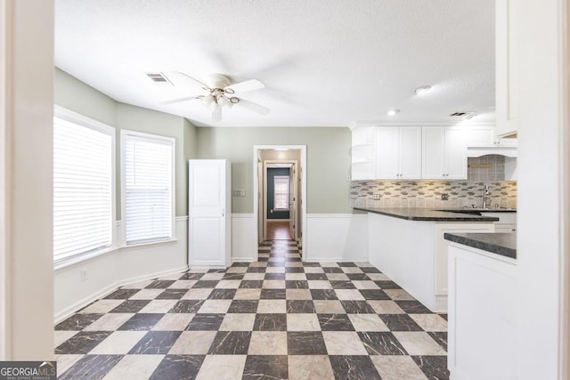 kitchen featuring visible vents, a ceiling fan, open shelves, dark countertops, and white cabinets