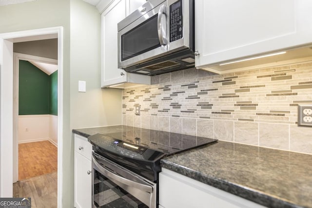 kitchen with white cabinetry, wood finished floors, and appliances with stainless steel finishes