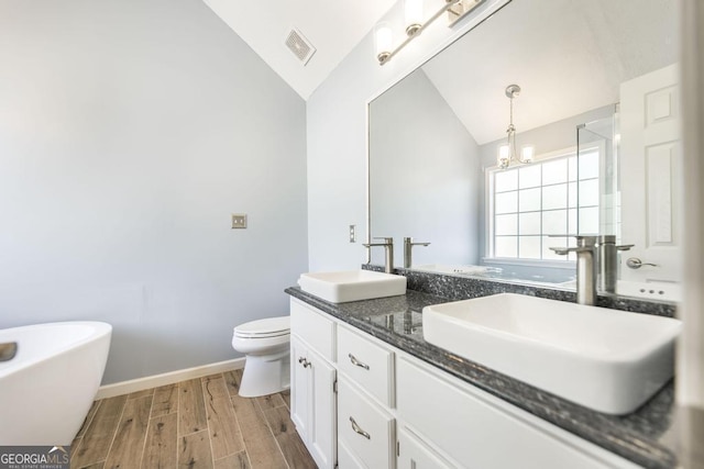 full bath with vaulted ceiling, visible vents, wood finished floors, and a sink