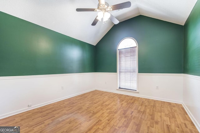 empty room featuring a ceiling fan, lofted ceiling, and wood finished floors