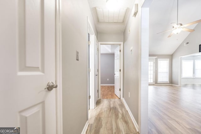 hallway featuring baseboards, visible vents, and light wood-type flooring