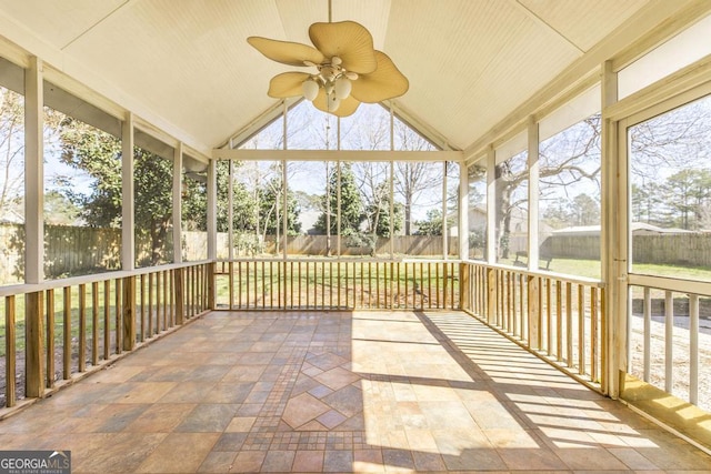 unfurnished sunroom with a ceiling fan and lofted ceiling