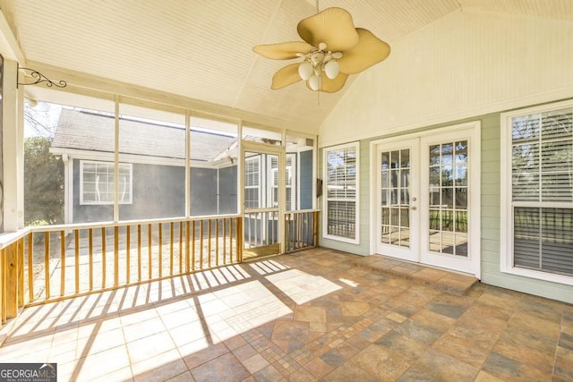 unfurnished sunroom with a ceiling fan, vaulted ceiling, and french doors