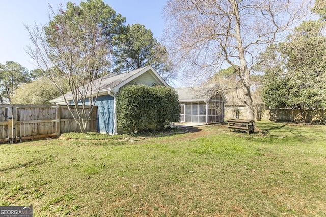 view of yard featuring a sunroom and fence