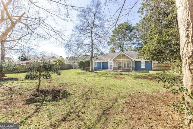 view of yard featuring a fenced backyard and a sunroom