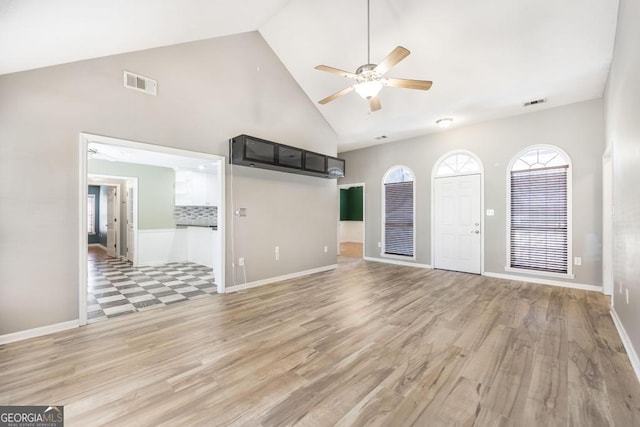 unfurnished living room featuring visible vents, high vaulted ceiling, light wood-style floors, and a ceiling fan