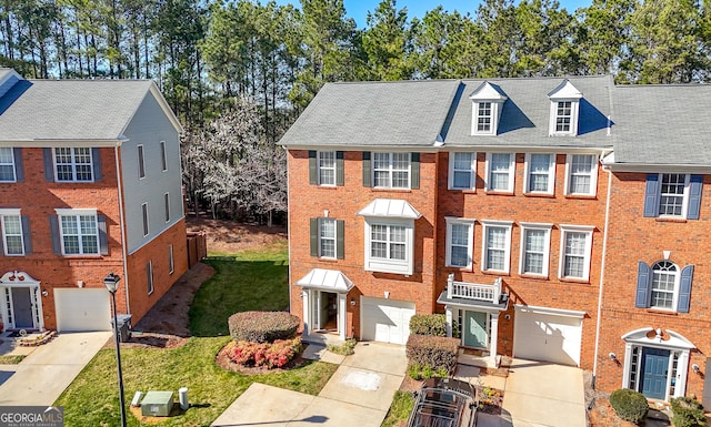 townhome / multi-family property featuring brick siding, driveway, and a garage