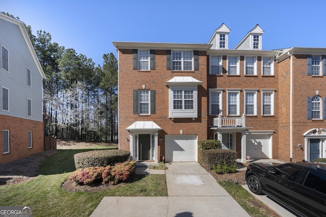 townhome / multi-family property with brick siding, an attached garage, and driveway