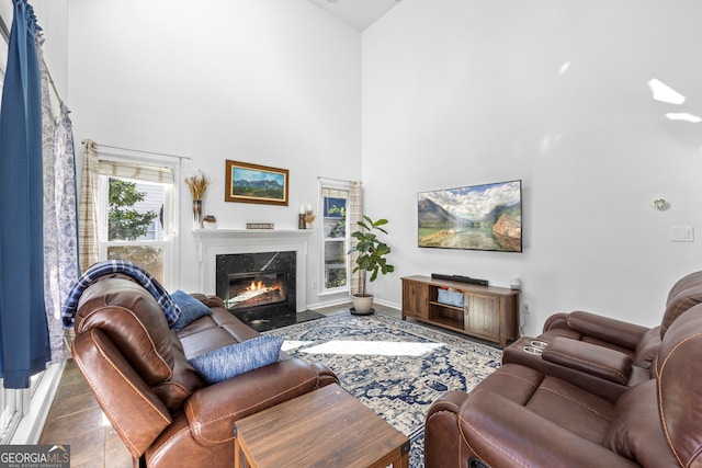 living room with a fireplace, a high ceiling, and baseboards