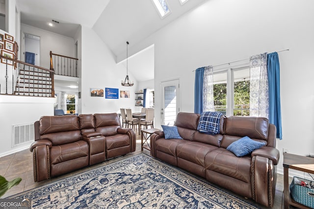 tiled living room featuring a wealth of natural light, visible vents, a skylight, and high vaulted ceiling