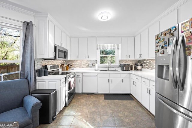 kitchen with a sink, decorative backsplash, light countertops, stainless steel appliances, and white cabinetry