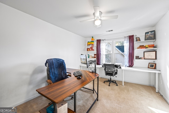 office area featuring visible vents, light colored carpet, baseboards, and a ceiling fan