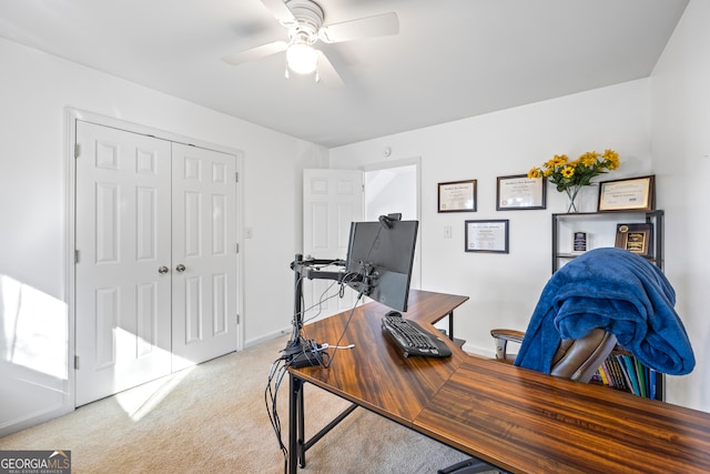 home office featuring baseboards, light carpet, and a ceiling fan